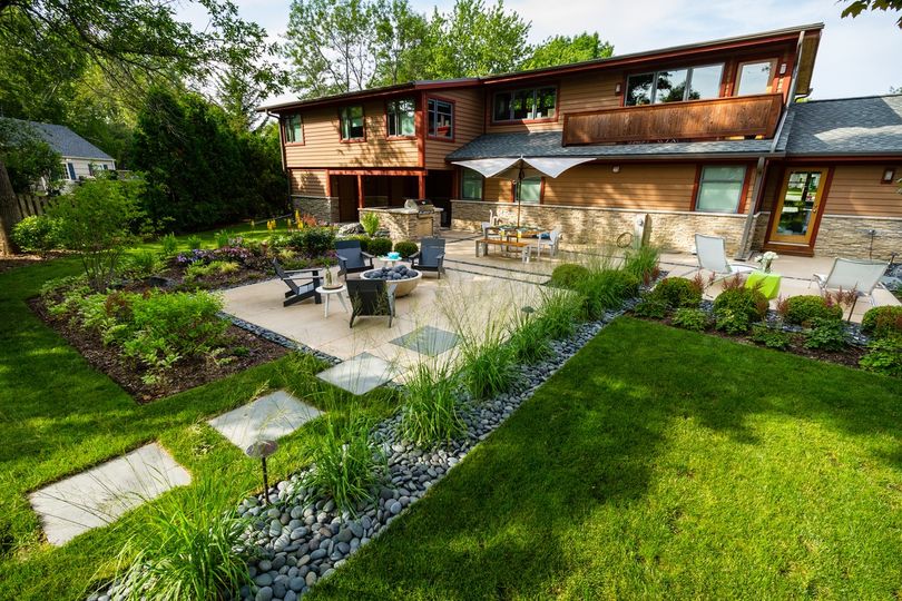 Grey beach pebbles used to fill accent border paths and add dimension to this midcentury landscape design