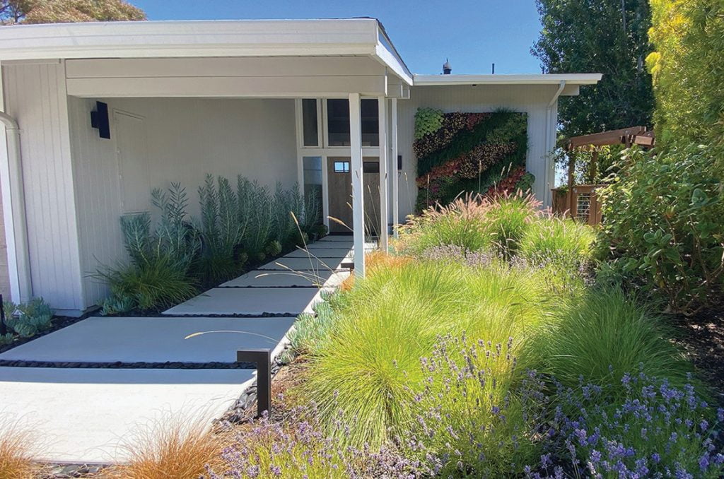 Beach pebbles are used to create a pebble pathway where landscape rocks are placed only between large pavers